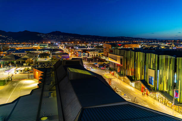 Christchurch Central: Colombo St Looking South In this 11 September 2020 photo shot at dusk, the mixed progress of the decade-long earthquake rebuild efforts in Christchurch Central are apparent. In the foreground centre is the Bus Interchange which opened in 2015. In the foreground right is the Christchurch EntX (Entertainment Central) building which features movie theatres and restaurants that opened in 2018. In the background are a number of car parks. Low-rise buildings damaged by the quakes used to occupy those sites. Empty spaces are a common sight across Christchurch where buildings once stood. The Port Hills are visible in the distance. The Canterbury Earthquakes struck on 4 September 2010 and 22 February 2011. christchurch earthquake stock pictures, royalty-free photos & images