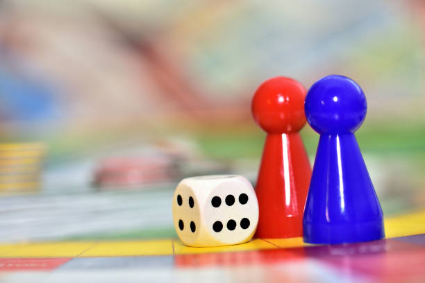 istock Blue, red play figures and dice on the board game. 1272017139