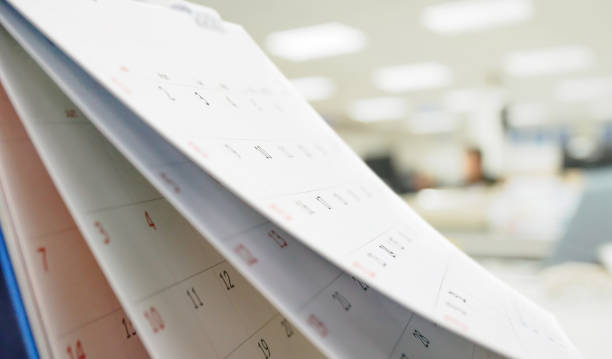 istock Close up white paper desk calendar on table with blurred office interior background 1272017242