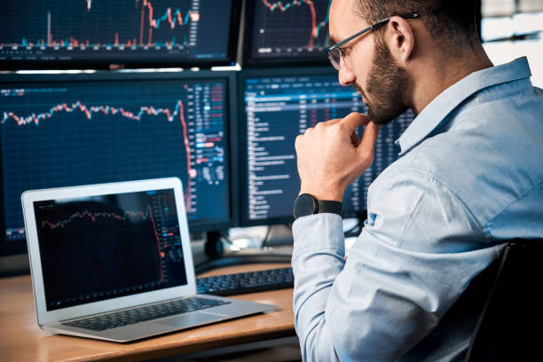 istock Stock Traiding. Trader sitting at office looking at laptop interpreting candlestick price chart pensive close-up 1272017448
