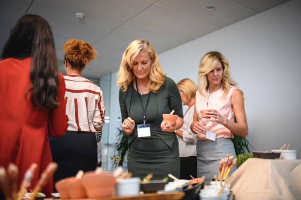 istock Female Executives Examining Gourmet Appetizers at Party 1272017514