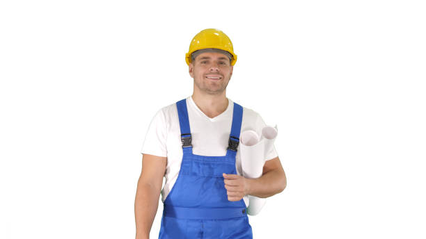 istock Construction worker walking with blue prints and smiling to camera on white background 1272018183