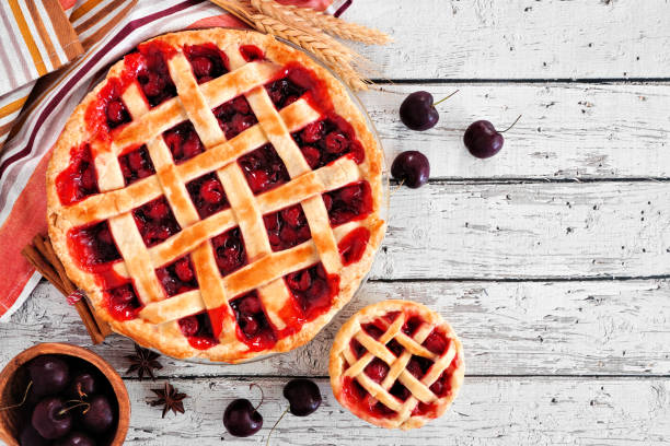 istock Cherry pies. Top view table scene against a white wood background. 1272018250