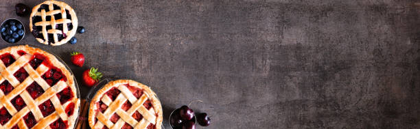 istock Selection of fresh fruit pies. Above view corner border over a dark stone background with copy space. 1272018368
