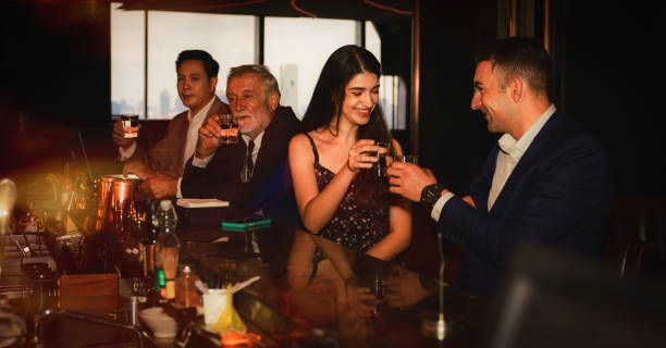 empresários em terno de negócios brindando copos de uísque para celebrar a amizade em bar - club suit - fotografias e filmes do acervo