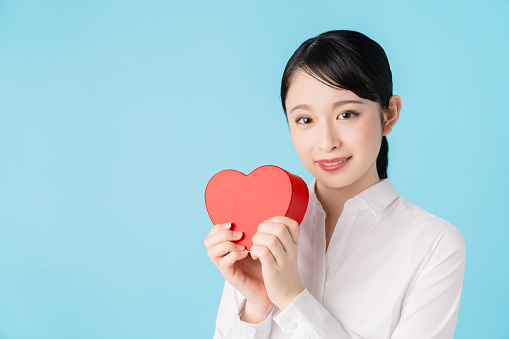 Asian woman holding a heart shape box.