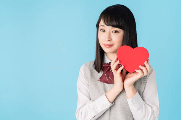 istock Asian school girl holding a heart shape box. 1272025323