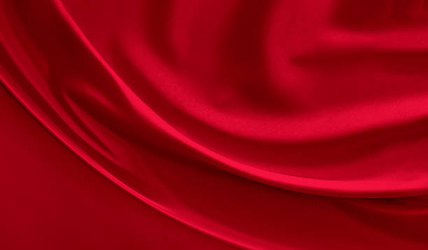 Black red satin dark fabric texture luxurious shiny that is abstract silk cloth background with patterns soft waves blur beautiful.