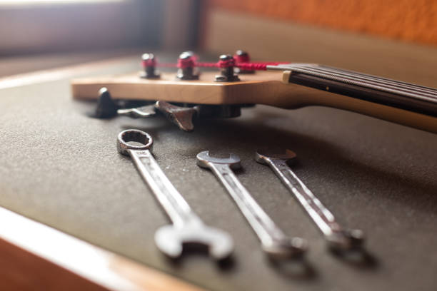 istock Portrait of guitar head and three wrenches lying on workbench of studio 1272036255