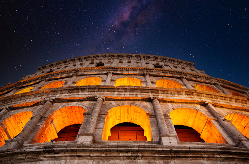 the wall of the colosseum with golden light at night in Rome, Italy,  header photo