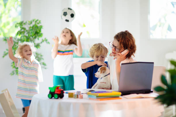 mutter arbeitet von zu hause aus mit kindern. quarantäne. - white dog audio stock-fotos und bilder