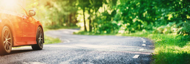 red car on asphalt road in summer - panoramic scenics sunlight day imagens e fotografias de stock