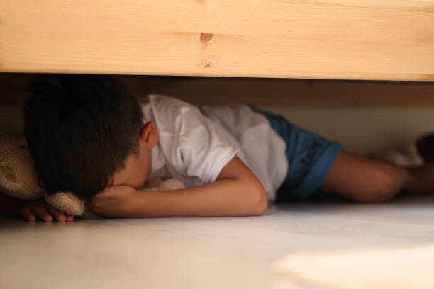 scared boy scared boy hiding stock pictures, royalty-free photos & images