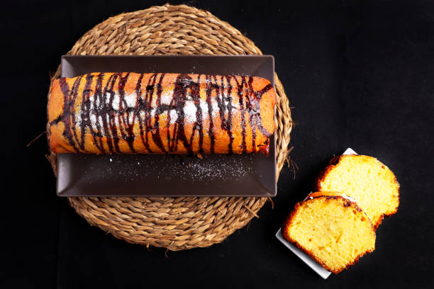 homemade yogurt cake with caramel coating top view Delicious homemade yogurt cake, with caramel coating, viewed from above and with a black background, two slices are tilted to complete the still life. Relish stock pictures, royalty-free photos & images