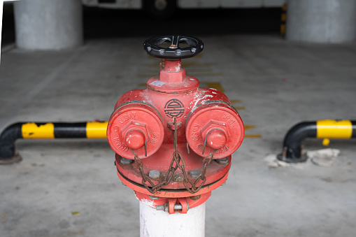 A Fire Hydrant, Waterplug, or Firecock on City Street, Red Steel Pipe to Extinguish Fires, Urban Fire-Fighting Equipment. High quality photo