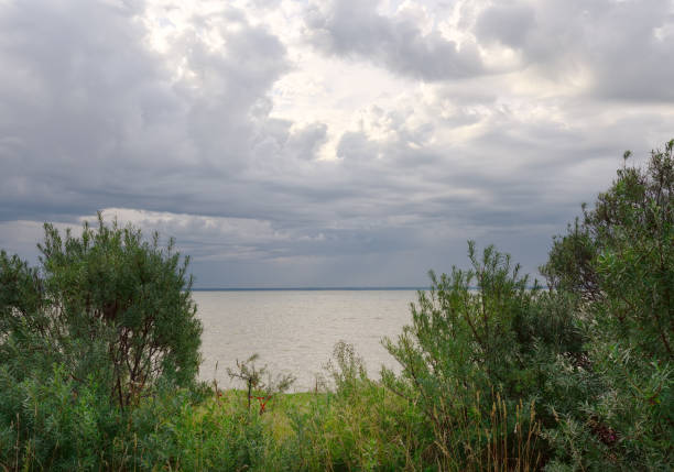 « fenêtre » dans les nuages au-dessus de la mer - horizon over water white green blue photos et images de collection