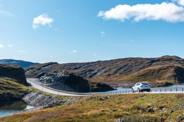 White Tesla X electric car driving Norway highway mountain road Myrkdalen, Norway - September 08, 2019: White Tesla X electric car driving Norway highway mountain road on sunny autumn bright day northern norway stock pictures, royalty-free photos & images