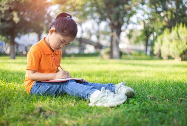 istock Cute little girl learning on the lawn 1272068127