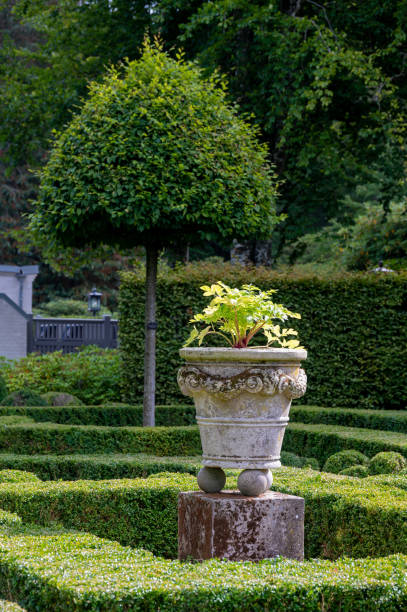 istock Ornate stone pot in well cut garden 1272068259