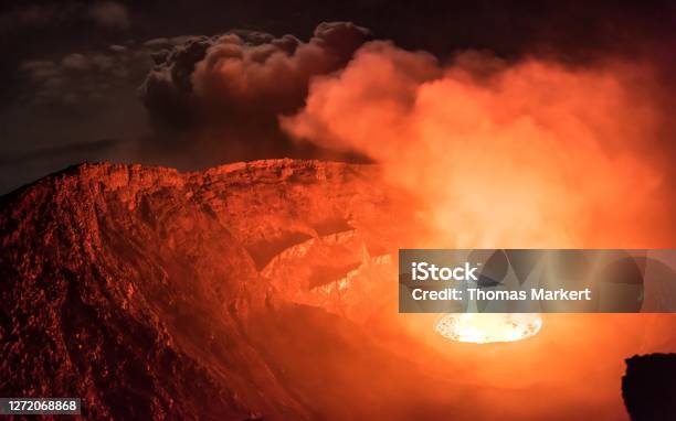 Glowing Clouds Of Smoke Emitted From Lava Lake Inside Active Nyiragongo Volcano Lit By Moonlight Stock Photo - Download Image Now