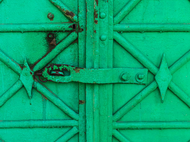 замок монтировать на старых зеленых металлических ворот - вход в храм - fort castle reliability lock стоковые фото и изображения