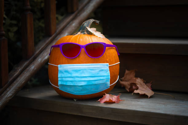 Pumpkin dressed up for Halloween with COVID PPE face mask Pumpkin dressed up for Halloween with COVID PPE face mask pumpkin decorating stock pictures, royalty-free photos & images