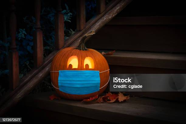 Lighted Halloween Pumpkin Jack O Lantern Wearing Covid Ppe Mask On Steps Stock Photo - Download Image Now