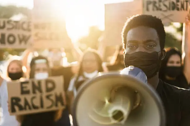 People from different culture and races protest on the street for equal rights. Focus on black man eyes