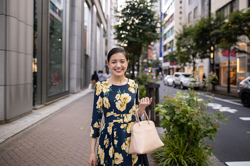Portrait of young businesswoman standing on city street