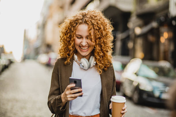 istock A young woman is using mobile phone on the move 1272073924