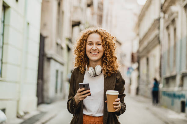 istock A young woman is using mobile phone on the move 1272074117