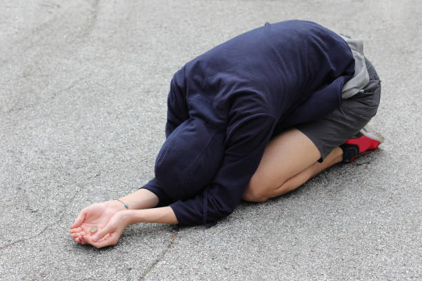 istock young gypsy crouched on the ground asks for alms 1272074175