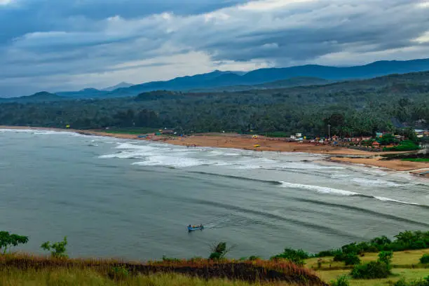 Photo of mountain top view of sea shore with clouded sky