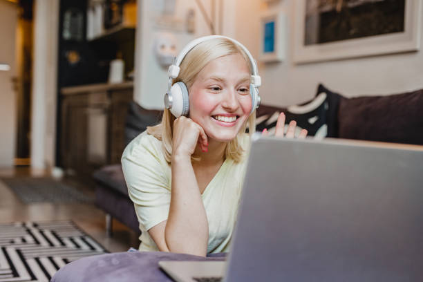istock A young woman is watching something on a laptop at home 1272083302