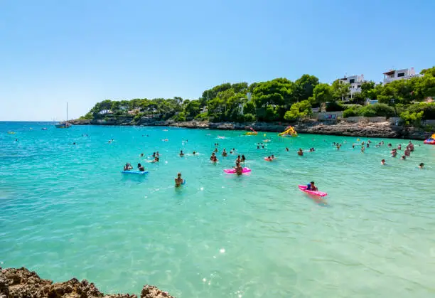 Photo of People swimming in Cala Gran bay in Cala D'Or, Mallorca, Spain