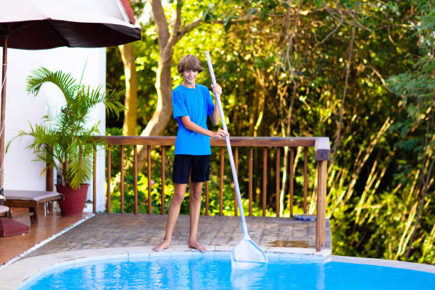 istock Boy cleaning swimming pool. Maintenance, service. 1272084181