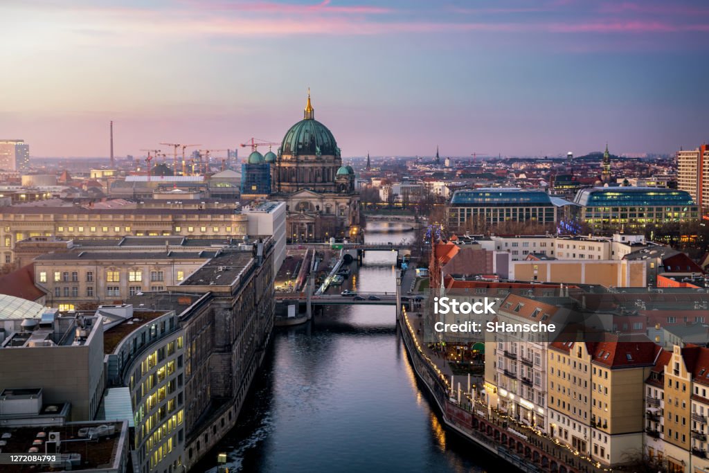 View along the river Spree to the Berlin Cathedral and  urban skyline of Berlin, Germany View along the river Spree to the Berlin Cathedral and  urban skyline of Berlin, Germany, with city lights and soft sunset sky Berlin Stock Photo