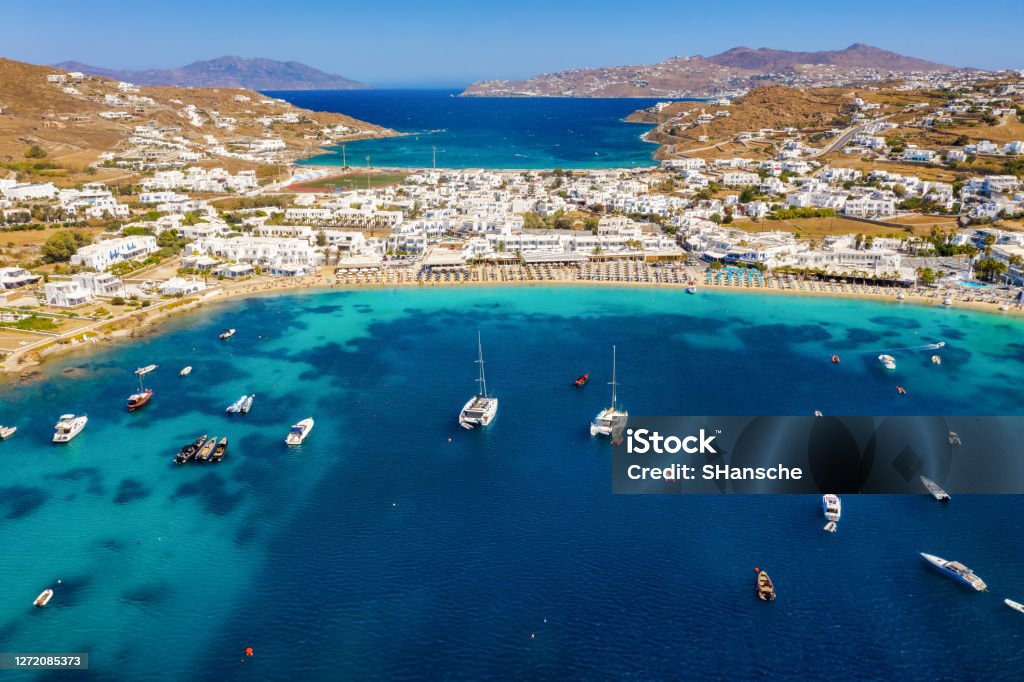 Aerial view to the popuar bay of Ornos on the island of Mykonos, Greece Aerial view to the popuar bay of Ornos on the island of Mykonos, Greece, with many yachts moored in front of the beautiful beach Mykonos Stock Photo