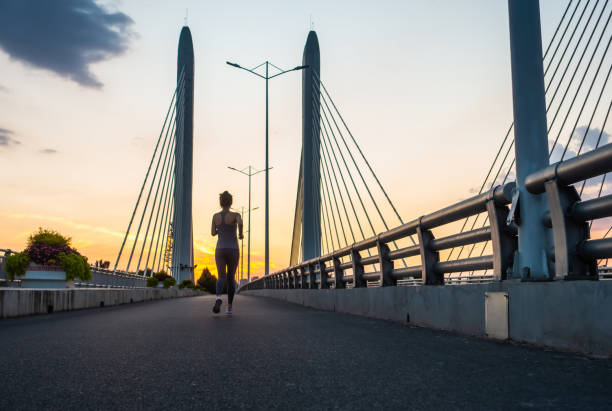 istock Young women jogging on bridge in morning 1272086540