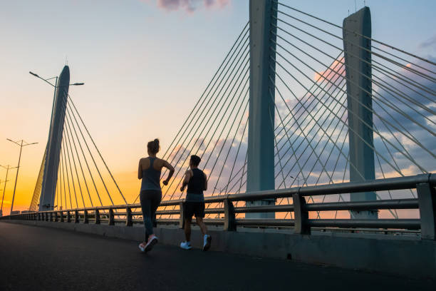 istock Young couple jogging on bridge in morning 1272086558
