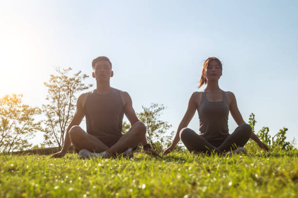 istock Couple doing yoga training in park 1272087367