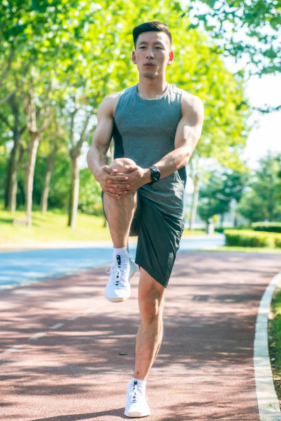 Young man stretching in the park Young man stretching in the park touching toes stock pictures, royalty-free photos & images