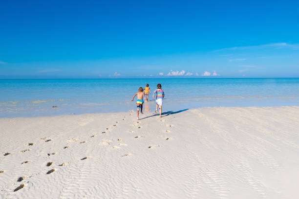 istock Kids playing on beach. Children play at sea. 1272090349