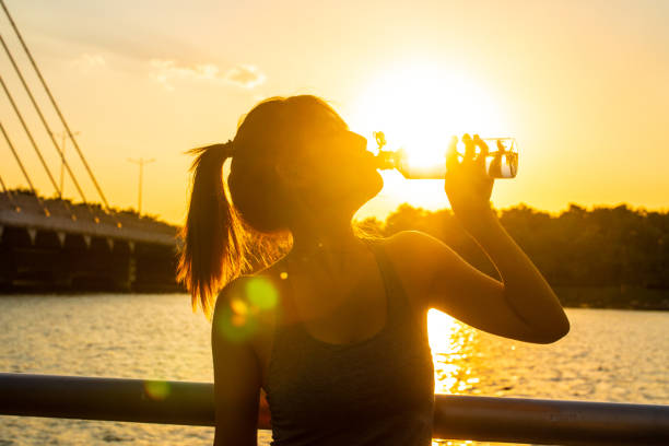 Young woman drinking water after jogging exercising