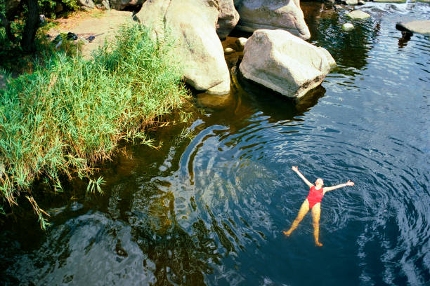 Woman swimming in river in summer Young Caucasian woman swimming in river in summer. Camera film analog photos stock pictures, royalty-free photos & images
