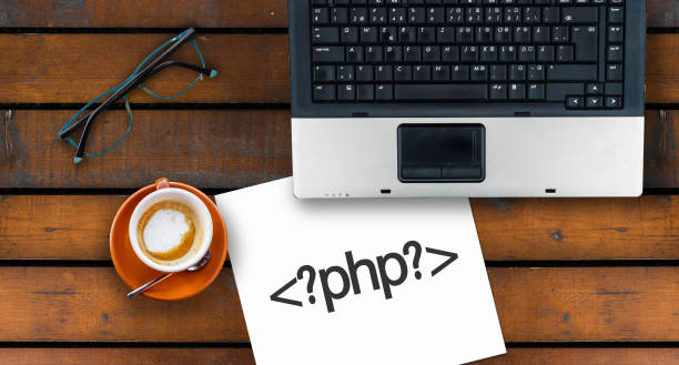 istock Paper width PHP and laptop, glasses and coffee on wooden table 1272096991