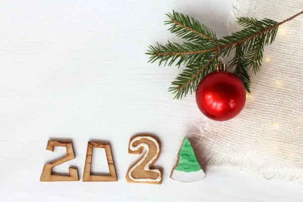 numbers, a cookie, a Christmas tree, and a red ball on a background of light garlands