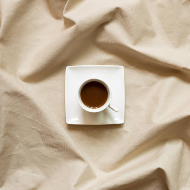 istock Cup of coffee on brown fabric background. top view 1272104166