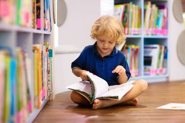 istock Child in school library. Kids reading books. 1272104221