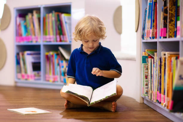 istock Child in school library. Kids reading books. 1272104242